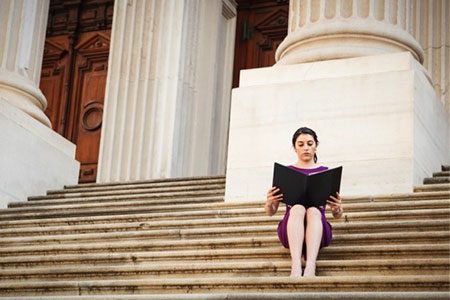 paralegal sitting on steps outside courthouse