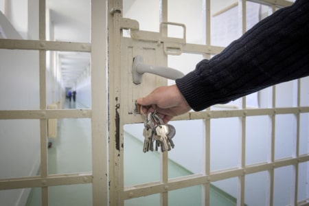correctional officer opening door with key