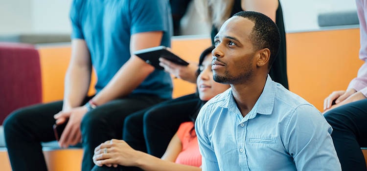 grad school student sits in lecture hall with other students