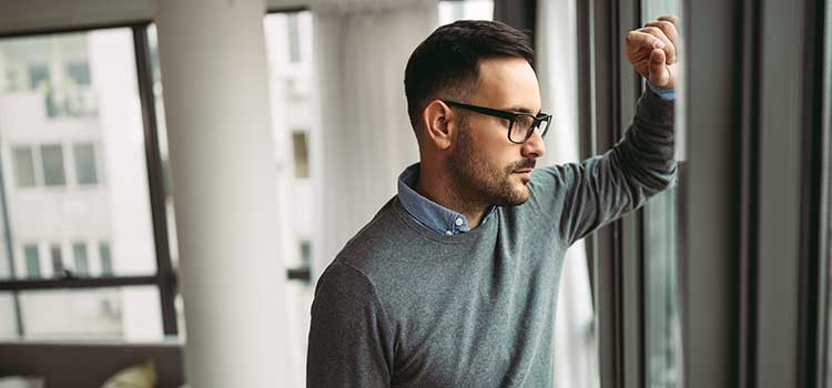man contemplating decision looking out window