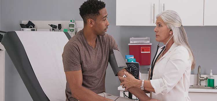 man getting medical exam from female doctor