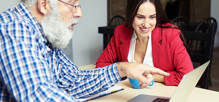 two psychologists discuss laptop screen in office