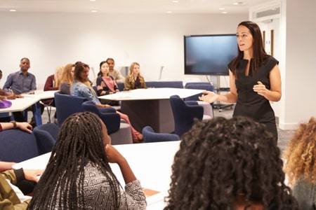 woman giving presentation to room full of people
