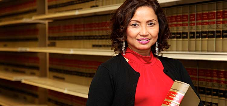 woman paralegal selects law book from legal library