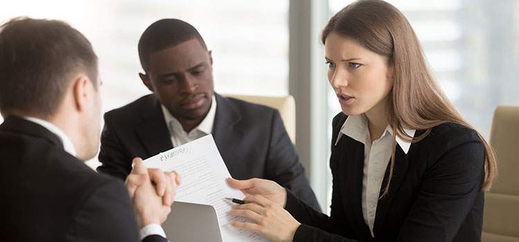 serious looking woman shows male colleagues document