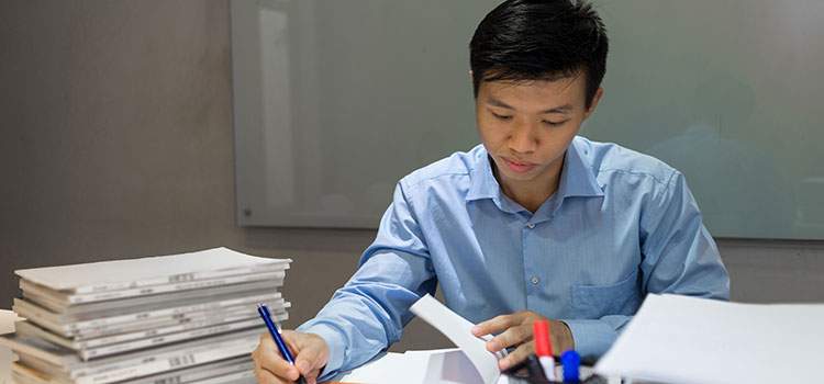 male paralegal looking through a stack of case files