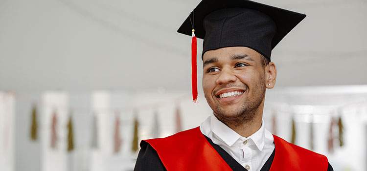 smiling man with mortarboard at college graduation