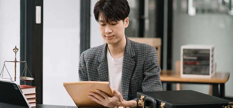 male paralegal works on notes for lawyer boss