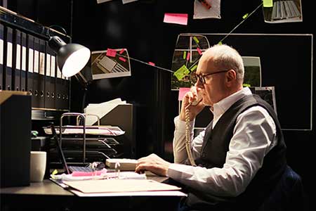 a property and evidence custodian works at a desk and makes calls in the evidence room of a law enforcement agency