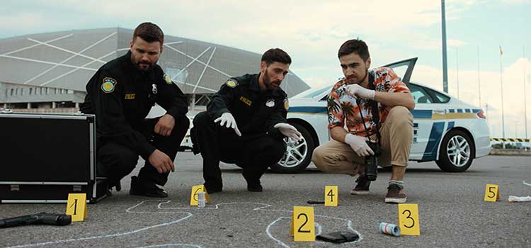 forensic science technician listens to police officer as he gets ready to photograph the crime scene