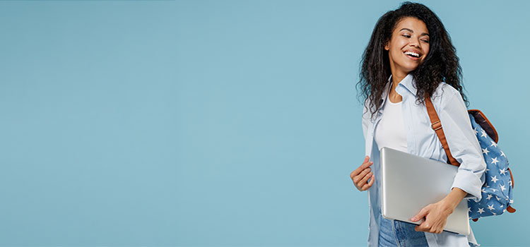 computer science college student walks carrying laptop