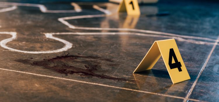 blood splattered on a crime scene next to a chalk body outline