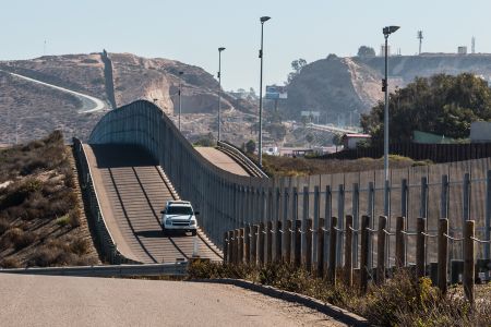 a border patrol truck drives alongside the U.S. and Mexico border