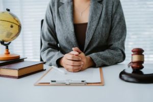 legal professional sits with their hands on their desk next to a gavel