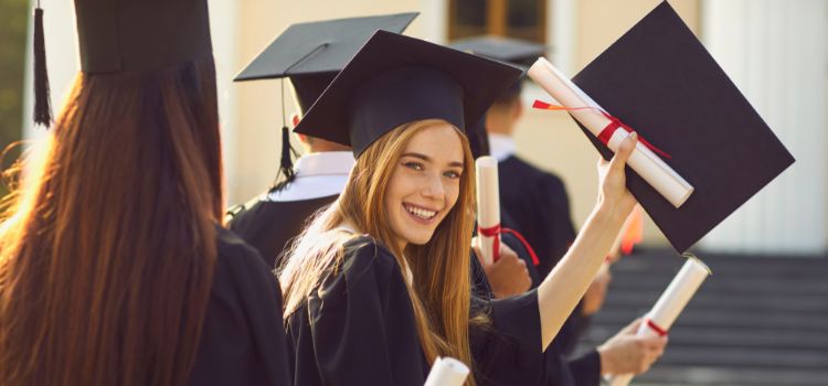 a criminal justice college graduate smiles at the camera and holds up her diploma